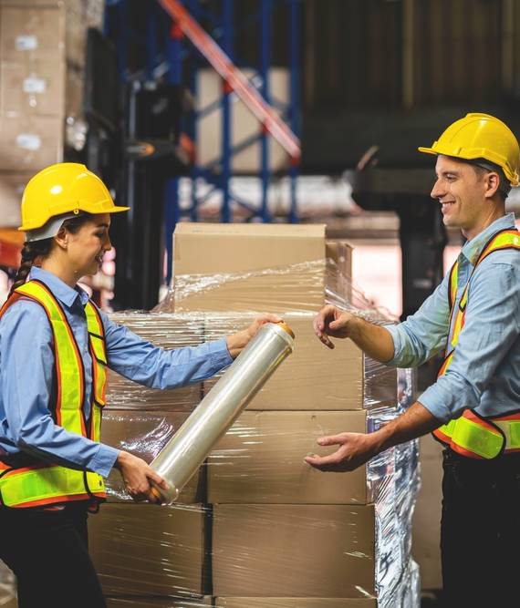 Worker,Wrapping,Boxes,In,Stretch,Film,At,Warehouse.,Workers,Work