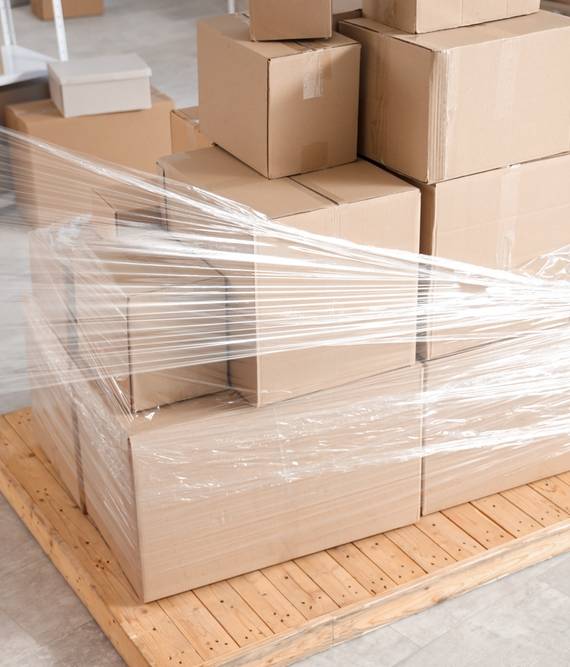 Male,Loaders,Wrapping,Boxes,On,Pallet,With,Stretch,Film,In