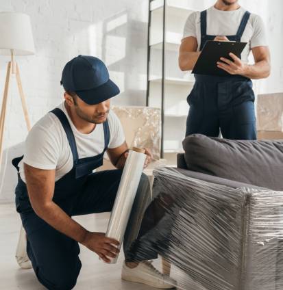 Indian,Mover,In,Cap,Holding,Stretch,Film,Roll,Near,Sofa